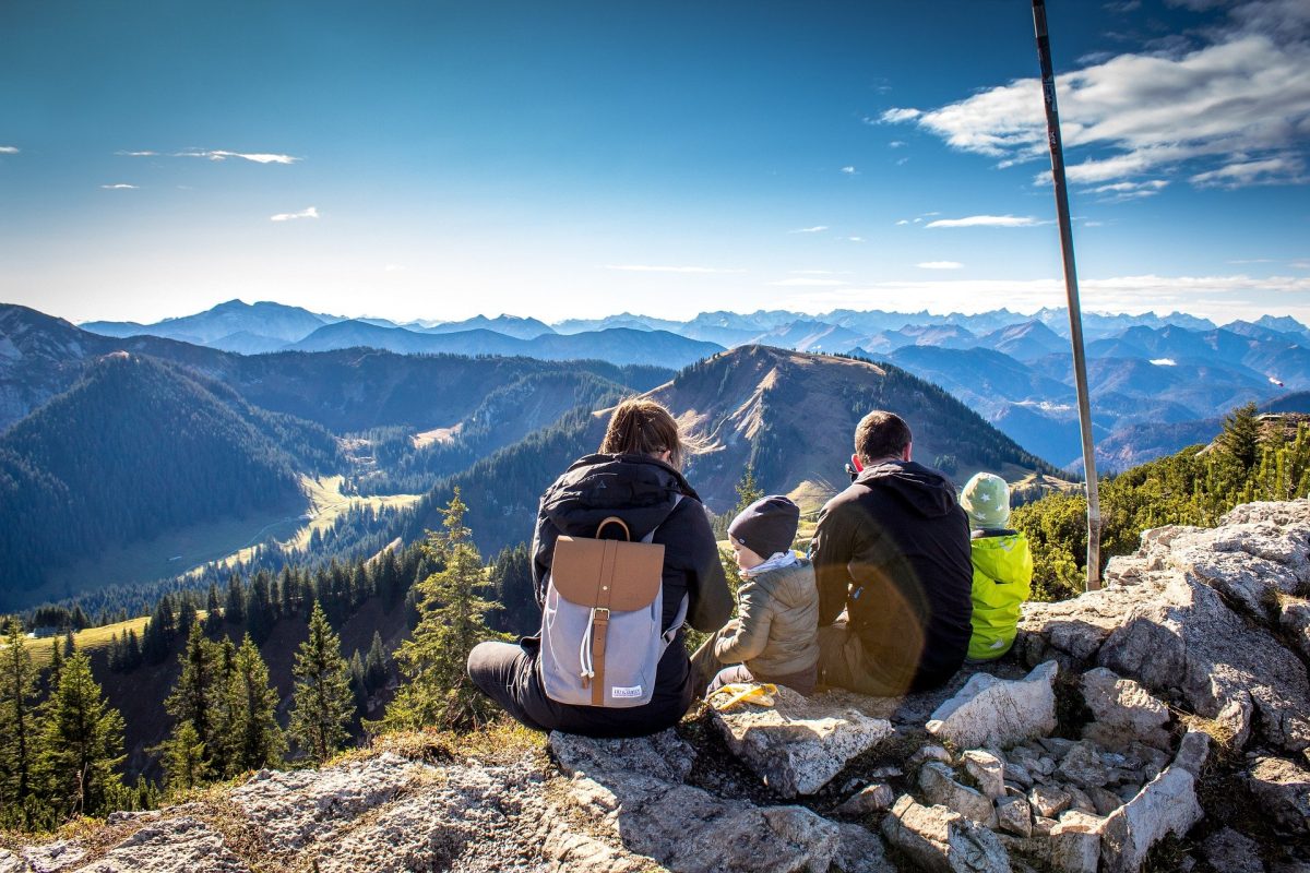 Family on a cliff looking at mountain scenery